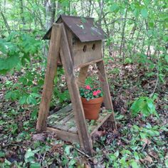 a wooden bird house with flowers in it