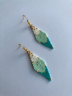 two pairs of beaded earrings with green and white beads on the ends, hanging from gold - plated hooks