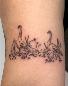 a woman's leg with three geese and flowers on the bottom part of her thigh