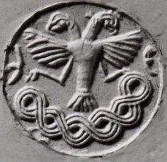 an ancient coin with a crucifix in the middle and two snakes on it