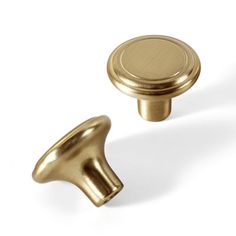 two brass knobs on a white background