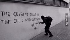 a man walking down a sidewalk next to a wall with graffiti on it and the words, the creative adult is the child who survived