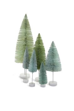 three small trees in white vases on a white surface with one green and the other blue