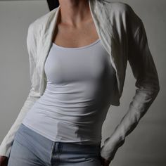 a woman in white shirt and jeans posing for the camera with her hands on her hips