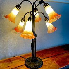 a lamp that is sitting on top of a wooden table in front of a wall