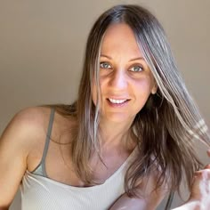 a woman brushing her hair with a brush