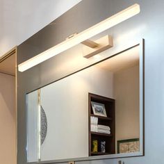 a bathroom with a sink, mirror and lights on the wall above it's counter