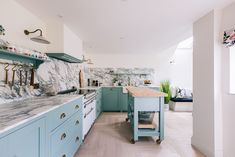 a kitchen with blue cabinets and marble counter tops