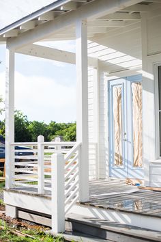 a white house with a blue door and porch