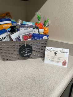 a gray basket filled with food sitting on top of a counter next to a sign