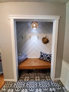 an entry way with a bench and decorative tile