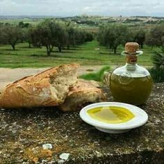 a bottle of olive oil next to a loaf of bread