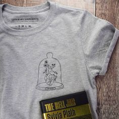 a book and t - shirt sitting on top of a wooden floor