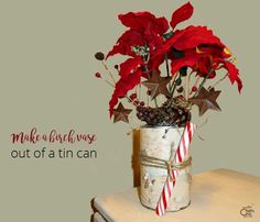 a vase filled with red flowers on top of a wooden table next to a candy cane