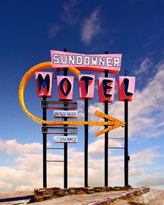 the sundowner motel sign is in front of a blue sky