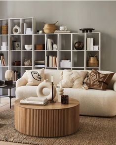 a living room with furniture and bookshelves on the wall, including a coffee table