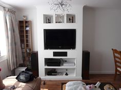 a living room filled with furniture and a flat screen tv on top of a white entertainment center