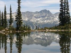 a lake surrounded by pine trees and mountains