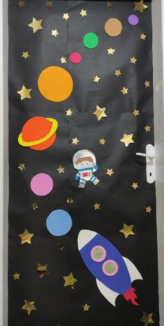 an outer space door decoration with stars, planets and a rocket ship in the sky