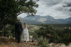 a bride and groom walking up a hill