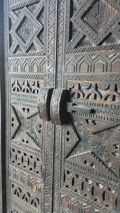 an ornate wooden door with metal handles