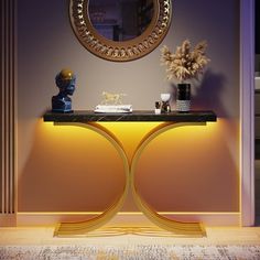 a table with a mirror and vase on it in front of a wall mounted sculpture