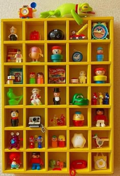 a yellow shelf filled with lots of toy figurines