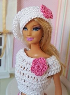 a doll is wearing a crocheted hat and dress