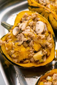 stuffed squash with meat and mushrooms on a metal tray, ready to be cooked in the oven