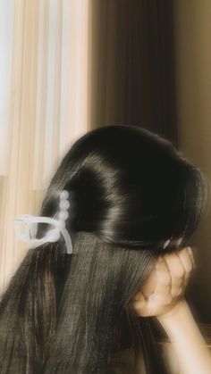 a woman with long black hair and a pair of scissors in her hair