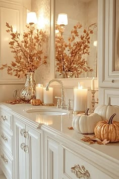 a white bathroom with candles and pumpkins on the counter