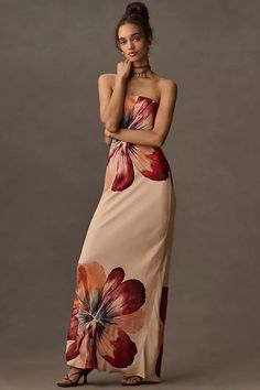 a woman in a long dress with flowers on it