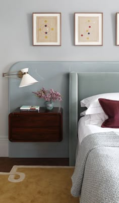 a bedroom with two framed pictures above the bed