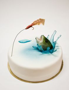 an image of a cake with a fish on it and a fishing hook in the middle