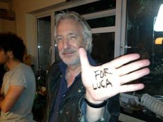 a man holding up his hand with the word for lucia written on it in front of him