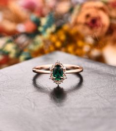 a close up of a ring on a table with flowers in the backgroud