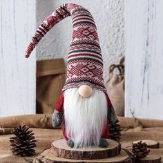 a gnome figurine sitting on top of a wooden table next to pine cones