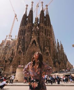 a woman standing in front of a very tall building