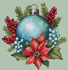 a cross stitch christmas ornament with holly and poinsettis