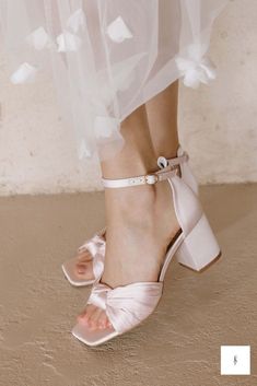 a bride's feet wearing pink shoes and a white dress with flowers on it