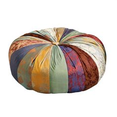 a multicolored patchwork poufce sits on top of a white surface