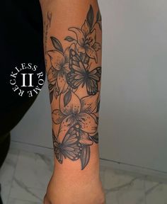 a woman's arm with black and white flowers on the left side of her body