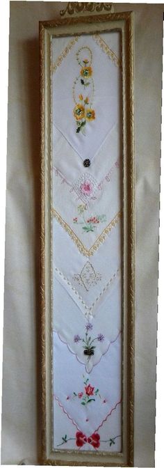 a cross stitch sample in a gold frame with flowers and hearts on the bottom half