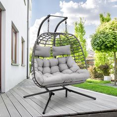 a swing chair with cushions on the back porch