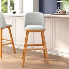 two wooden stools sitting in front of a counter