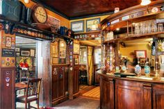 the inside of a bar with lots of clocks on the wall