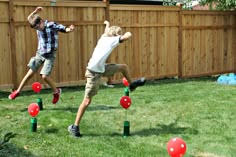 two young men playing with red and green bouncy balls in their backyard area