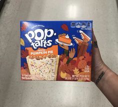 a hand holding a box of pop tarts pumpkin pie