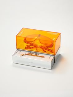 an orange pair of glasses sitting in a box