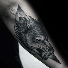 a man's arm with a wolf head on it and an arrow in the middle